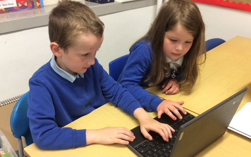 Students at St Wilfrids using a laptop together in compiting class